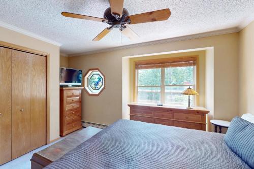 a bedroom with a ceiling fan and a bed and a dresser at Saddle Ridge Townhome 402 in Silverthorne
