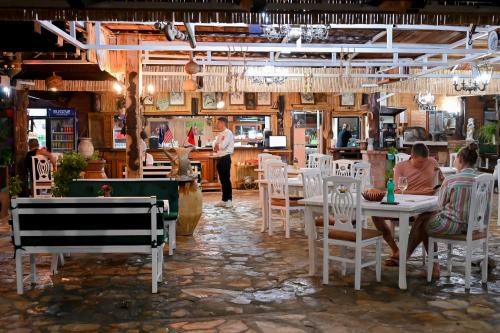 a restaurant with people sitting at tables in a room at Bujtina Syni Zi "Keshtjella" - Shengjin in Shëngjin