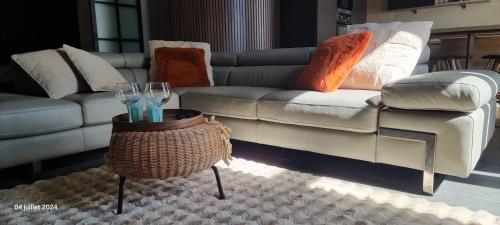 a living room with a couch and a table with wine glasses at Le Refuge de la Chapelle in Assesse