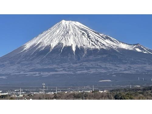 a snow covered mountain with a city in front of it at Fuji Park Hotel - Vacation STAY 23854v in Fuji