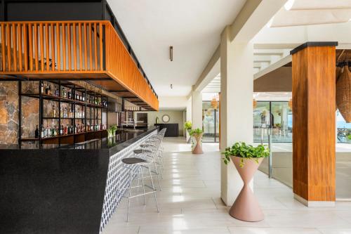 a lobby with a bar with stools at Dreams Cozumel Cape Resort & Spa in Cozumel