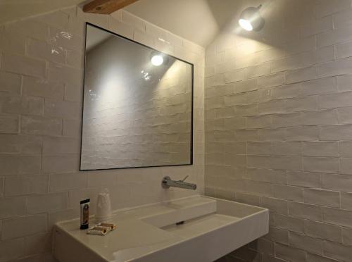 a white bathroom with a sink and a mirror at Beau Rivage in Charavines