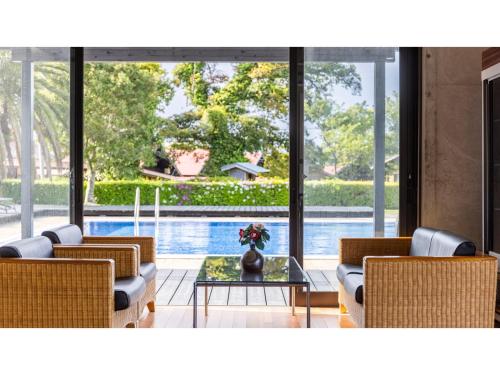 a living room with chairs and a table and a pool at Goto Conkana Kingdom - Vacation STAY 25614v in Goto