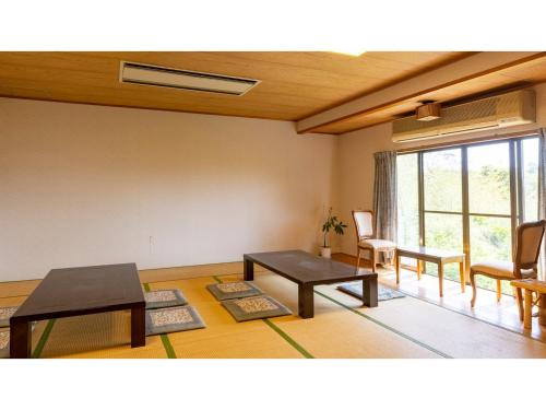 a living room with tables and chairs and a window at Goto Conkana Kingdom - Vacation STAY 29692v in Goto