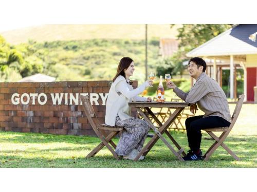 a man and woman sitting at a picnic table drinking wine at Goto Conkana Kingdom - Vacation STAY 29692v in Goto
