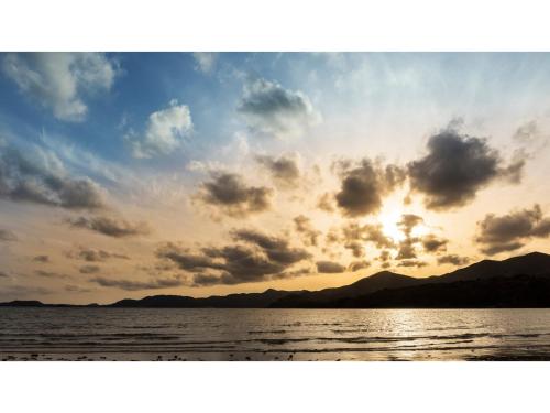 a sunset over a body of water with clouds at Goto Conkana Kingdom - Vacation STAY 29692v in Goto