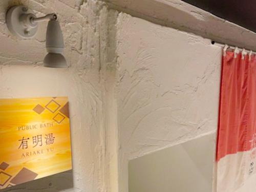 a wall with a lamp and a poster on it at Hotel Flags Isahaya - Vacation STAY 25620v in Isahaya