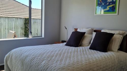 a bedroom with a bed with pillows and a window at Sweet Retreat in Richmond