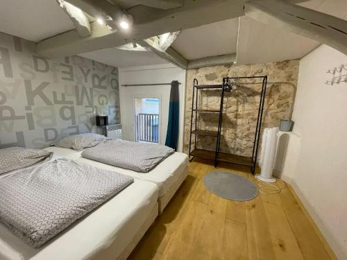 une chambre avec un lit et un mur en pierre dans l'établissement La Serva, à Les Lèches