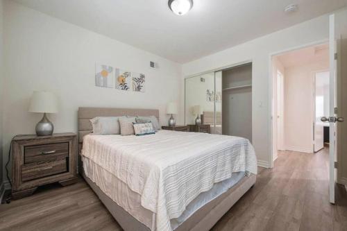 a white bedroom with a large bed and a night stand at Elm Mountain View Fire pit, quiet and more in Los Angeles