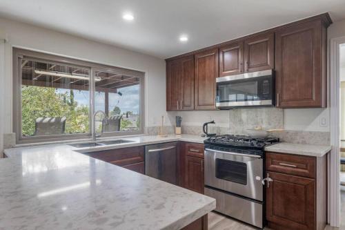 a kitchen with wooden cabinets and a stove top oven at Elm Mountain View Fire pit, quiet and more in Los Angeles