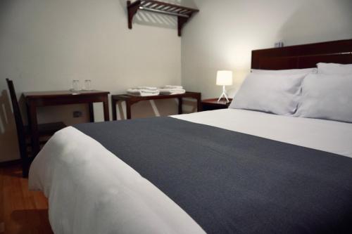 a bedroom with a bed and a table with a lamp at Colca Canyon Hotel by PERU HTL in Chivay