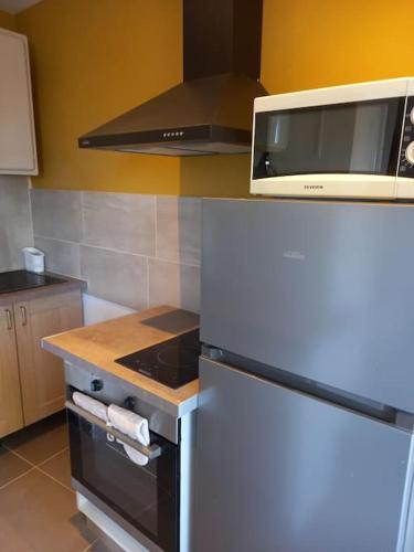 La cuisine est équipée d'un réfrigérateur blanc et d'un four micro-ondes. dans l'établissement Superbe appartement Fabrégas, à La Seyne-sur-Mer