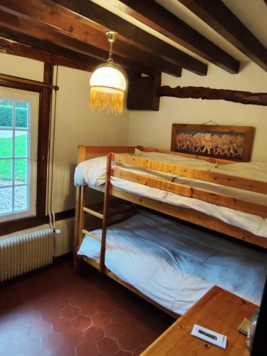 une chambre avec deux lits superposés et une table dans l'établissement Gîte Le Clos Maridor - Grande Longère Normande -15 personnes, à Saint-Martin-Saint-Firmin