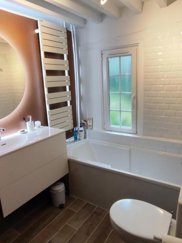 une salle de bain avec une baignoire, un lavabo et des toilettes dans l'établissement Gîte Le Clos Maridor - Grande Longère Normande -15 personnes, à Saint-Martin-Saint-Firmin