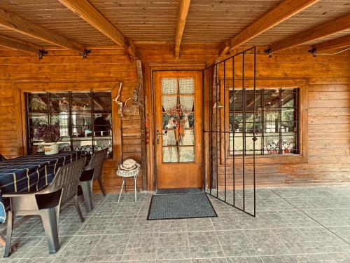 a screened in porch with a table and chairs at Woodhouse Xirolivado in Xirolívadon
