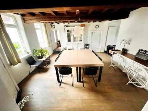 a large dining room with a table and chairs at Square Shaped Farmhouse from 1713 in Nieuwenhove
