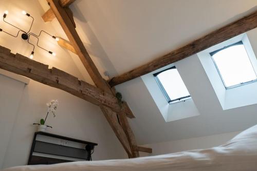 a bedroom with two windows and a bed at Square Shaped Farmhouse from 1713 in Nieuwenhove