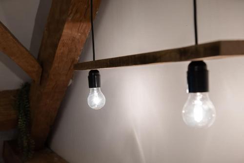 three light bulbs hanging on a wall at Square Shaped Farmhouse from 1713 in Nieuwenhove
