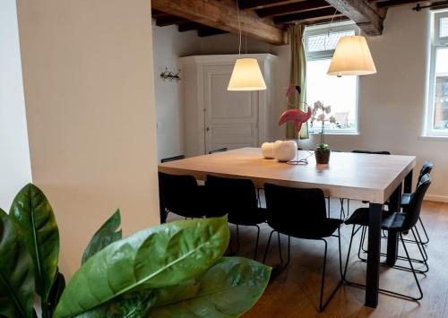 a dining room with a table and some plants at Square Shaped Farmhouse from 1713 in Nieuwenhove