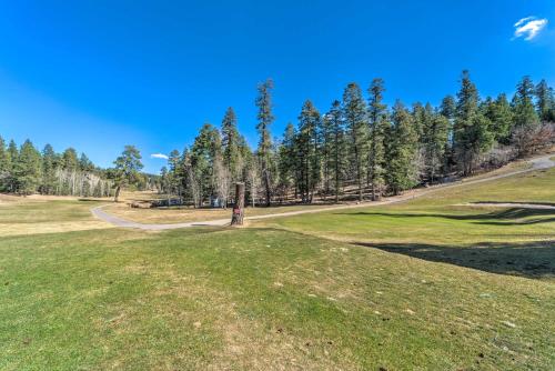 a view of a golf course with trees in the background at Cloudcroft Townhome on Golf Course with Deck! in Cloudcroft