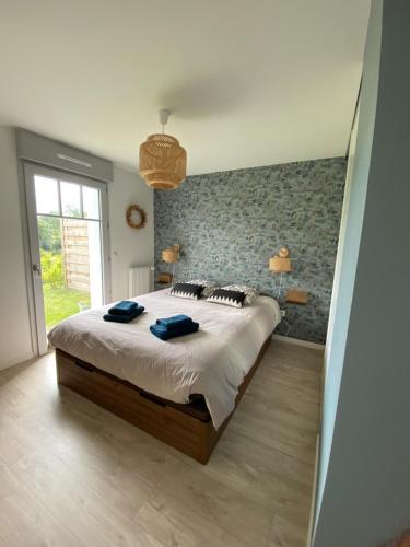 une chambre avec un lit avec deux serviettes bleues dessus dans l'établissement L'Olivier en Baie, T3 de standing avec jardin, vue baie, parking privé, à Saint-Valery-sur-Somme
