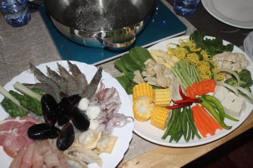 two plates of different types of food on a table at Deep Forest Garden Hotel in Puerto Princesa City
