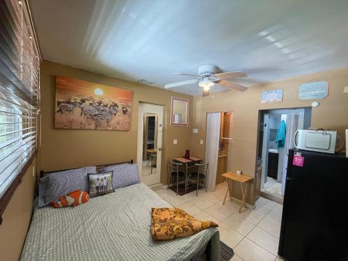 a living room with a bed and a ceiling fan at Cardoza family in North Lauderdale