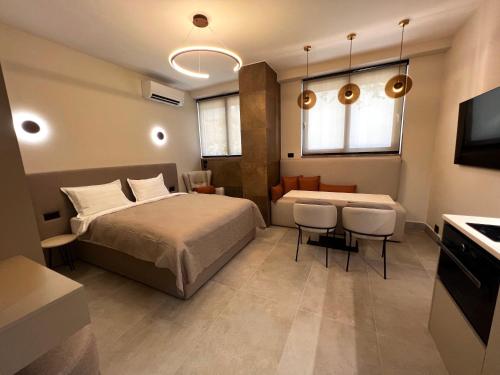 una camera da letto con un letto, un tavolo e delle sedie di Golden Beach Suites a Sarandë