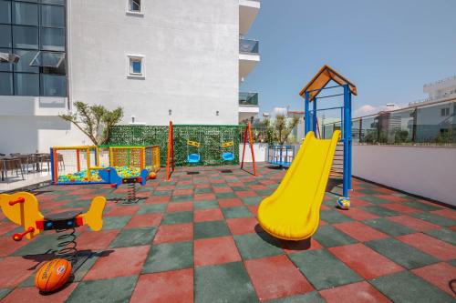 un parque infantil con tobogán y equipo de juegos en L'Amo del Mare Hotel, en Ksamil
