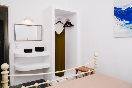 a room with a staircase with a bed and a mirror at Akrogiali Pension in Platis Yialos Sifnos