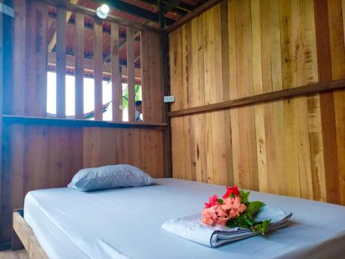 a bed with a bouquet of flowers on it at Posada Brisas del Cachcal in Panguí
