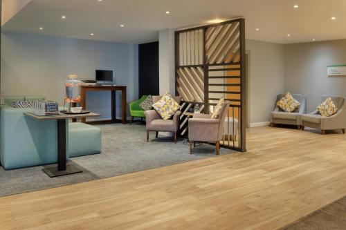 a waiting room with a table and chairs at Holiday Inn South Normanton M1, Jct.28 by IHG in South Normanton