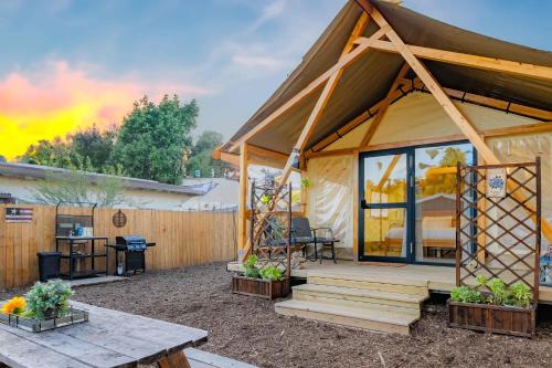 a wooden cabin with a porch and a table at Urban Oasis Luxe Glamping with King Bed & BBQ in Glendora