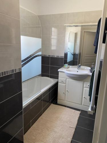 une salle de bain avec un lavabo, une baignoire et un miroir dans l'établissement Villa Golfe de Saint-Tropez, à La Môle