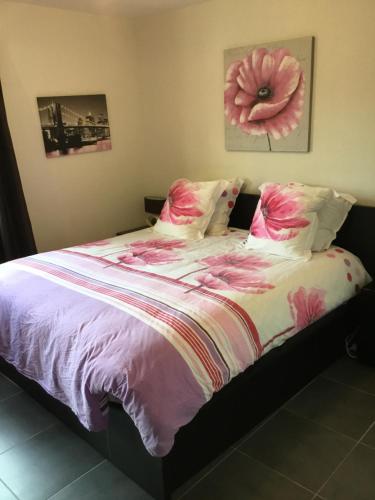 - une chambre avec un lit orné d'une fleur rose dans l'établissement Villa Golfe de Saint-Tropez, à La Môle