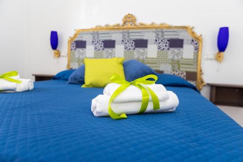 two beds with towels with a yellow ribbon on them at Ai Mercati di Palermo in Palermo