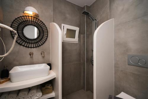 a bathroom with a sink and a shower at Akrogiali Pension in Platis Yialos Sifnos