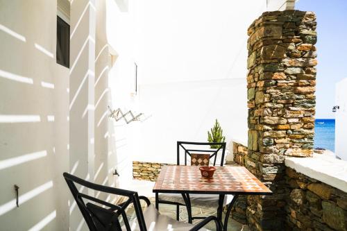 a table and chairs on a patio with the ocean at Akrogiali Pension in Platis Yialos Sifnos