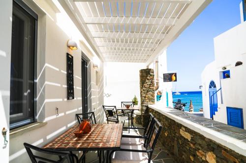 a balcony with tables and chairs and the ocean at Akrogiali Pension in Platis Yialos Sifnos