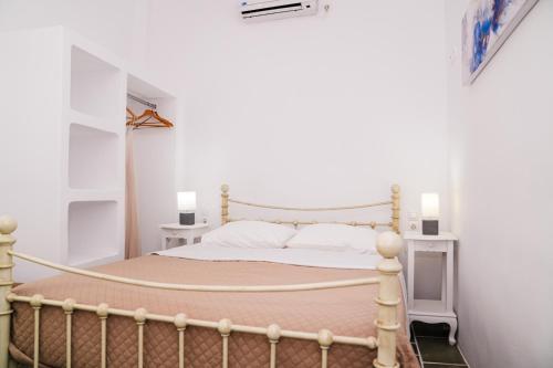 a bedroom with a large bed with white walls at Akrogiali Pension in Platis Yialos Sifnos