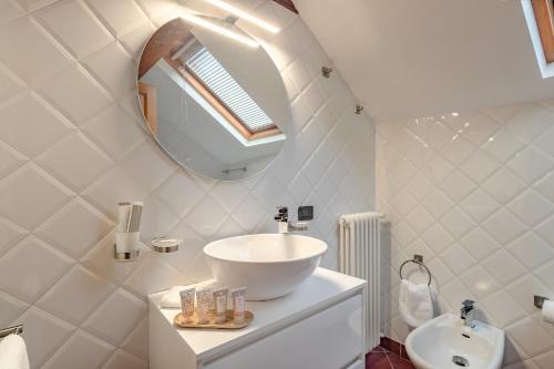 a white bathroom with a sink and a mirror at La Torretta "I Gabbiani" sul Lago Maggiore in Maccagno Inferiore