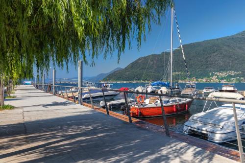a group of boats docked at a dock at La Torretta "I Gabbiani" sul Lago Maggiore in Maccagno Inferiore