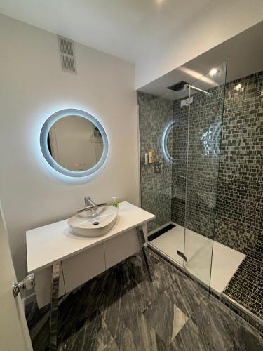 une salle de bain avec un lavabo et une douche en verre dans l'établissement Paris Ponthieu, à Paris