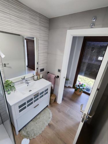 a bathroom with a white sink and a mirror at Villa Quelle in Sieiro