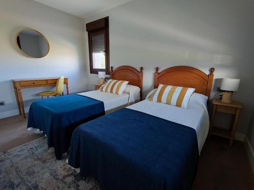 Un dormitorio con dos camas y una mesa y un espejo. en Villa Quelle, en Sieiro
