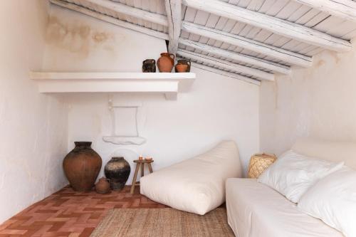 a white living room with a white couch and vases at Monte dos Coureleiros in Castelo de Vide