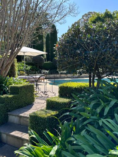 a garden with a pool and a table and trees at Guestlands Italia B&B in Arcadia