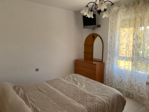 a bedroom with a bed and a dresser and a window at Cortijo LOS MIRADORES in Vélez Blanco