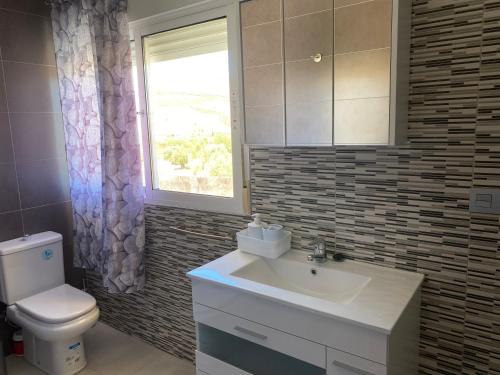 a bathroom with a sink and a toilet and a window at Cortijo LOS MIRADORES in Vélez Blanco
